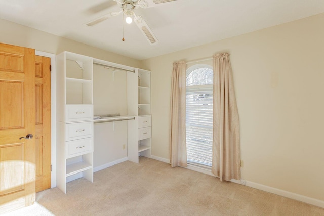 unfurnished bedroom with light carpet, multiple windows, and ceiling fan