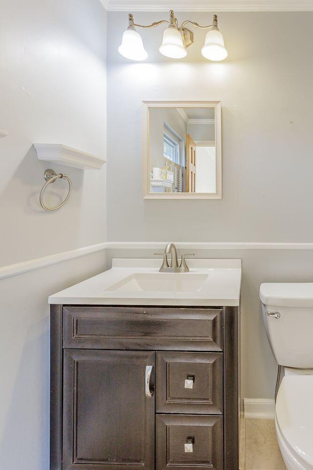 bathroom with vanity, toilet, and ornamental molding