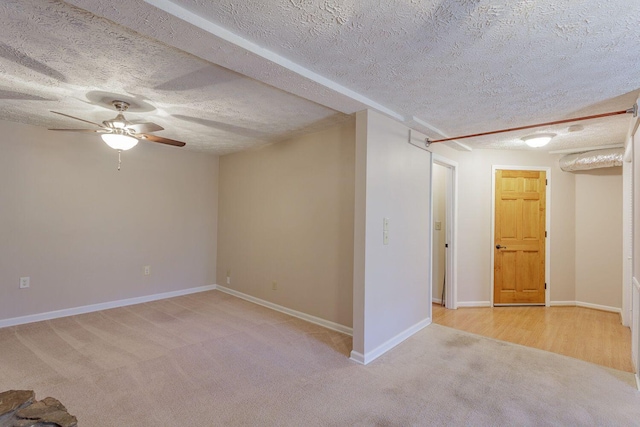 empty room featuring light carpet, ceiling fan, and a textured ceiling