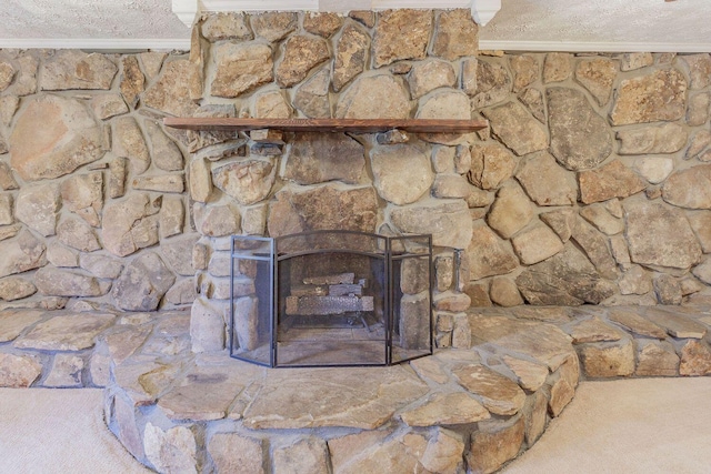 details with a textured ceiling, carpet floors, a stone fireplace, and ornamental molding