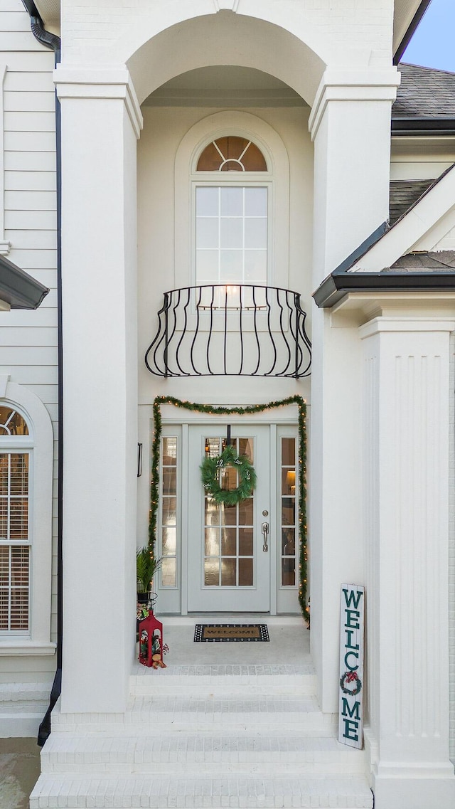 view of exterior entry with a balcony