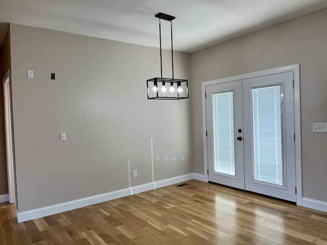 unfurnished dining area with french doors and light hardwood / wood-style flooring