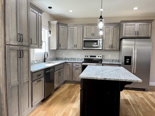 kitchen featuring hanging light fixtures, light wood-type flooring, and appliances with stainless steel finishes