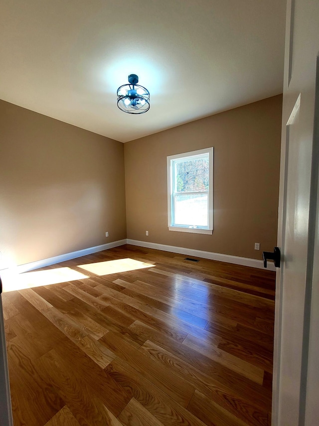 unfurnished room with hardwood / wood-style flooring