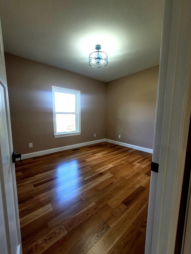 spare room with dark wood-type flooring