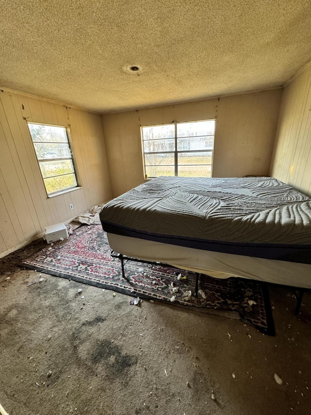 bedroom with carpet flooring, a textured ceiling, and multiple windows