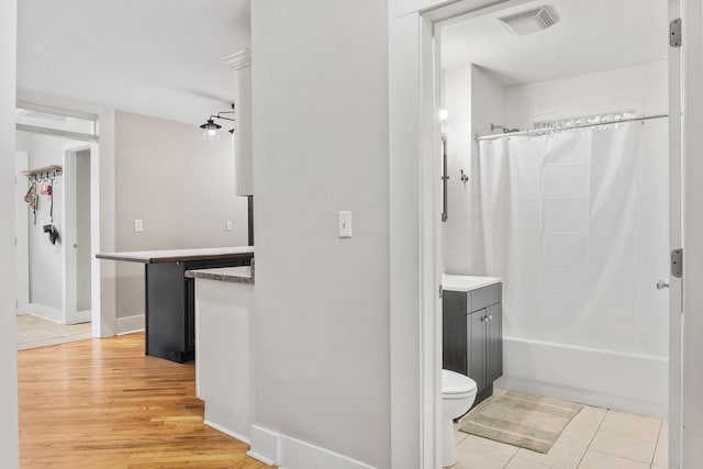 full bathroom with vanity, shower / bath combo with shower curtain, tile patterned flooring, and toilet