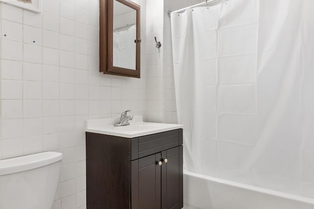 full bathroom with vanity, toilet, tile walls, and shower / tub combo with curtain