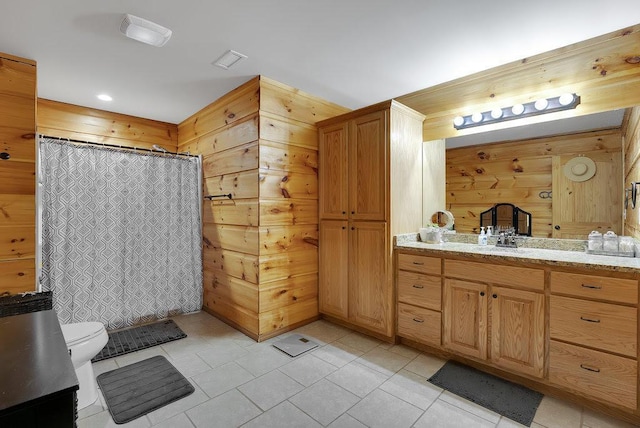 bathroom with vanity, tile patterned flooring, toilet, curtained shower, and wood walls