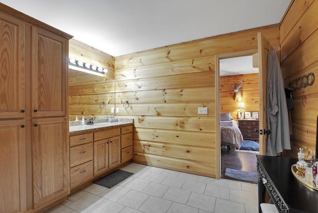 bathroom featuring vanity, tile patterned floors, and wooden walls