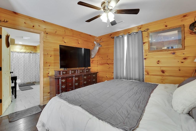 bedroom with dark hardwood / wood-style flooring, ceiling fan, and wood walls