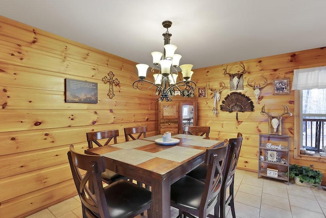 dining room featuring wood walls, light tile patterned floors, and an inviting chandelier