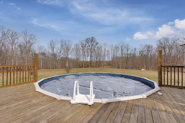 view of pool with a lawn and a wooden deck