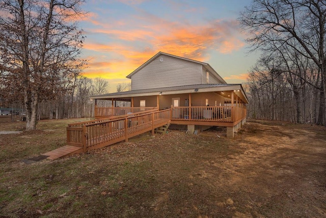 back house at dusk with a wooden deck