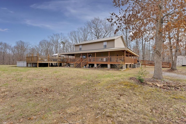 rear view of house with a storage unit, a lawn, and a wooden deck