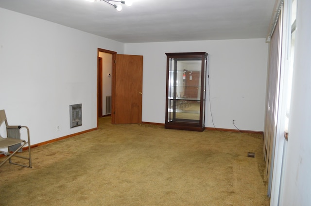 carpeted spare room featuring heating unit