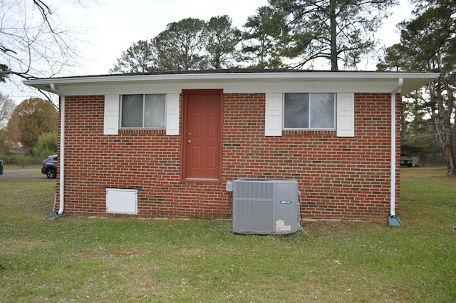 view of front of house with cooling unit and a front lawn