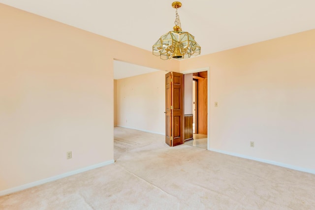 carpeted spare room with vaulted ceiling and an inviting chandelier