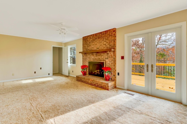 unfurnished living room with carpet, french doors, ceiling fan, and a fireplace