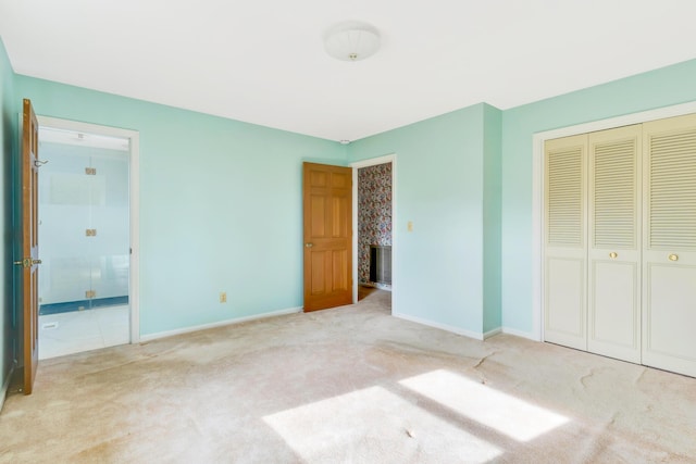 unfurnished bedroom featuring light carpet and a closet