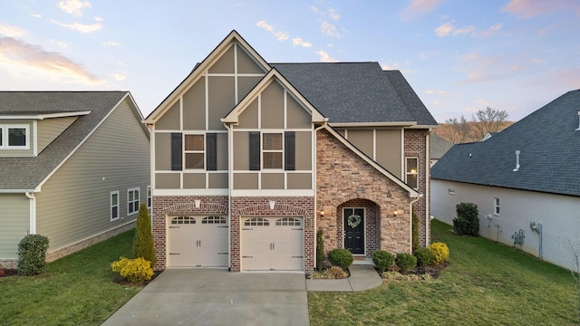 tudor-style house with a garage, a lawn, and a sunroom