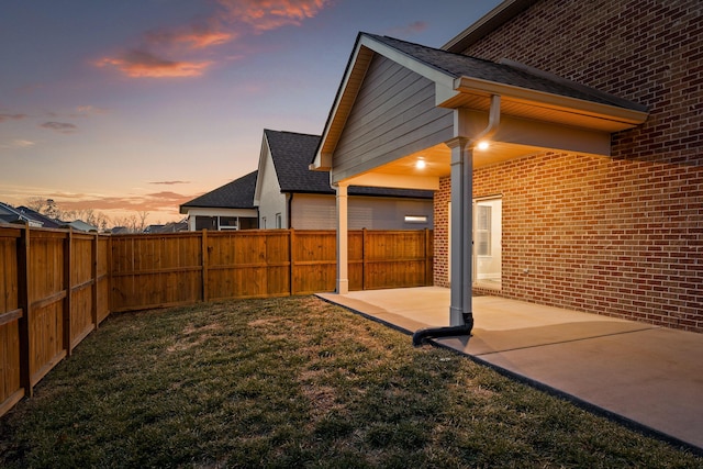 yard at dusk featuring a patio area