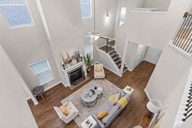 living room featuring a towering ceiling and dark wood-type flooring