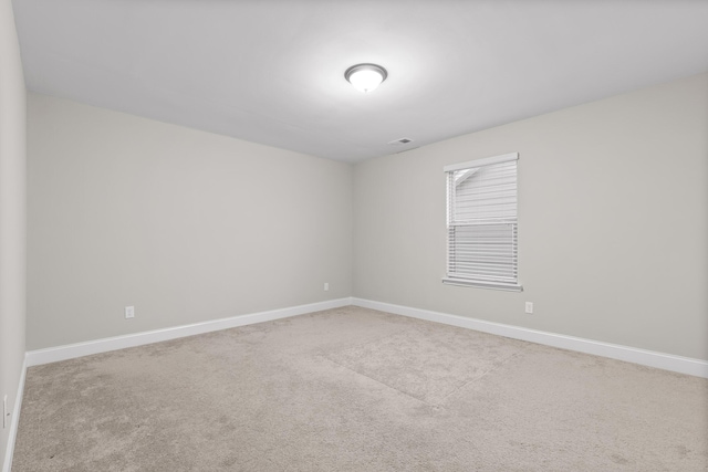 spare room featuring light colored carpet