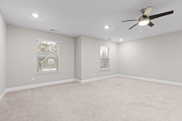 carpeted spare room featuring ceiling fan