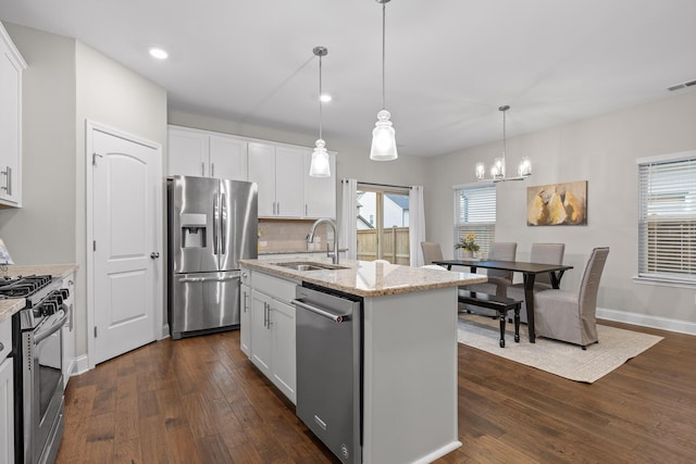 kitchen with white cabinetry, stainless steel appliances, sink, and a kitchen island with sink