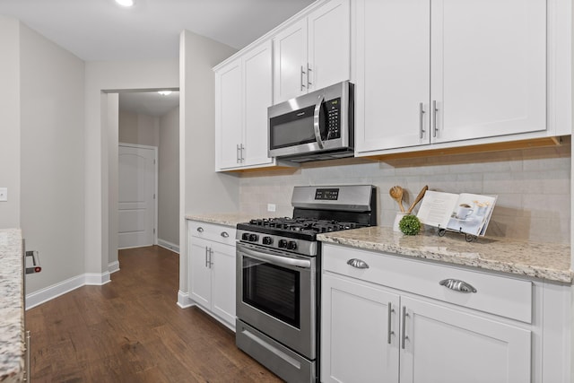 kitchen featuring tasteful backsplash, appliances with stainless steel finishes, dark hardwood / wood-style floors, light stone countertops, and white cabinets