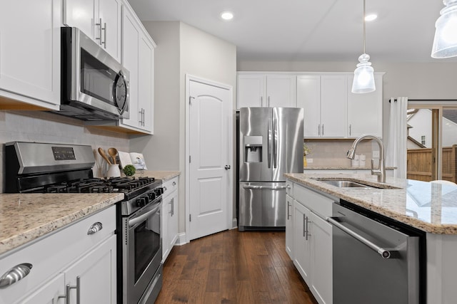 kitchen featuring sink, white cabinets, hanging light fixtures, stainless steel appliances, and light stone countertops