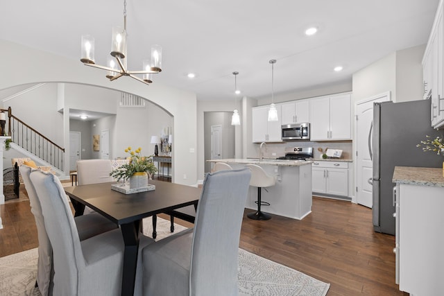 dining room with sink, a notable chandelier, and dark hardwood / wood-style floors