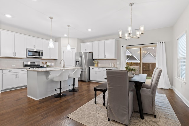 dining space with dark hardwood / wood-style floors, a chandelier, and sink