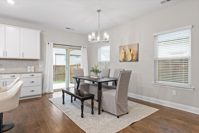 dining room featuring dark hardwood / wood-style floors and a chandelier