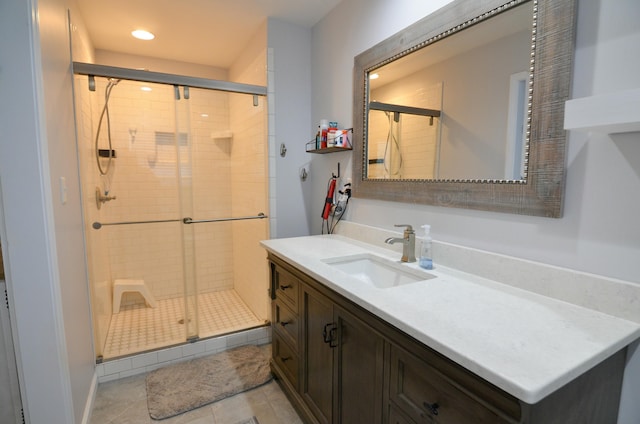 bathroom featuring tile patterned flooring, vanity, and a shower with door