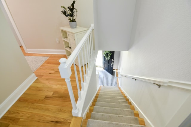 staircase with hardwood / wood-style flooring