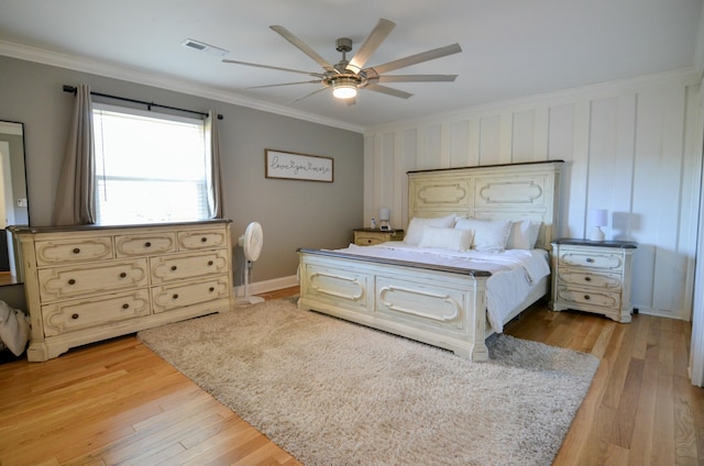 bedroom with ceiling fan, ornamental molding, and light wood-type flooring