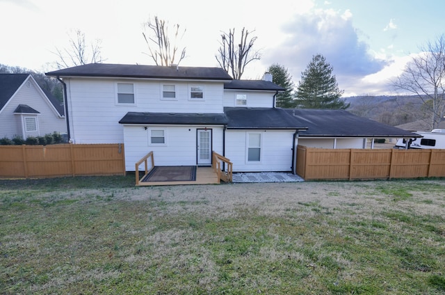 rear view of property featuring a lawn