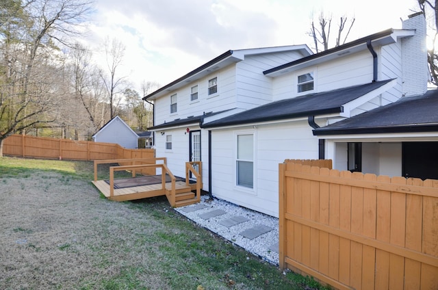 rear view of property featuring a lawn and a wooden deck