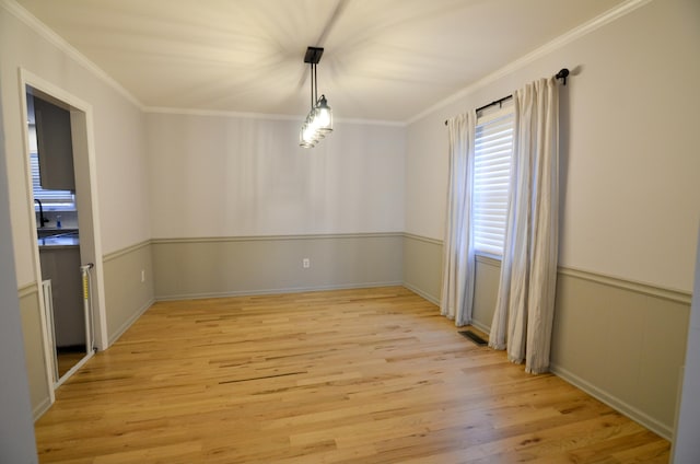 spare room with light hardwood / wood-style floors, ornamental molding, and sink