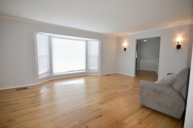 living room featuring crown molding and light hardwood / wood-style flooring