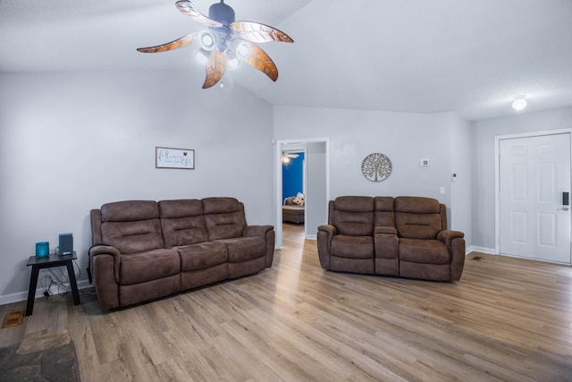 living room with ceiling fan, lofted ceiling, and light hardwood / wood-style flooring