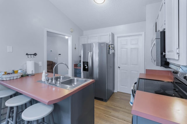 kitchen featuring white cabinets, a breakfast bar, sink, and stainless steel appliances