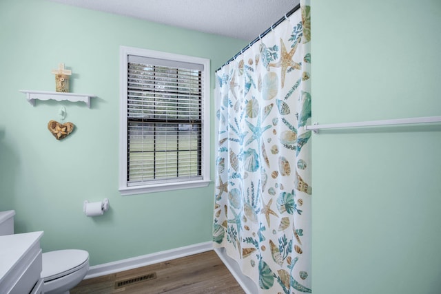 bathroom featuring vanity, a shower with shower curtain, toilet, a textured ceiling, and wood-type flooring