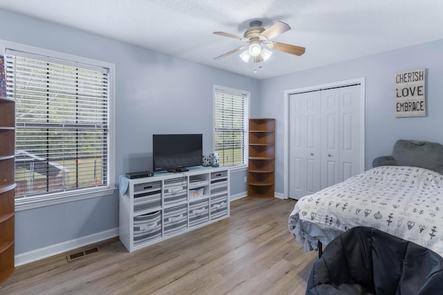 bedroom featuring ceiling fan, a closet, and light wood-type flooring