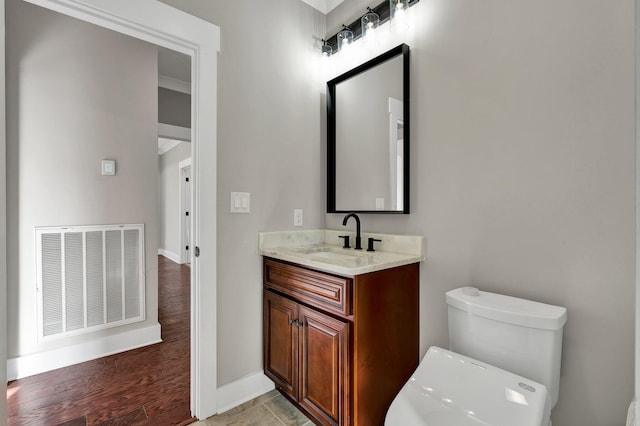 bathroom featuring vanity, hardwood / wood-style flooring, and toilet