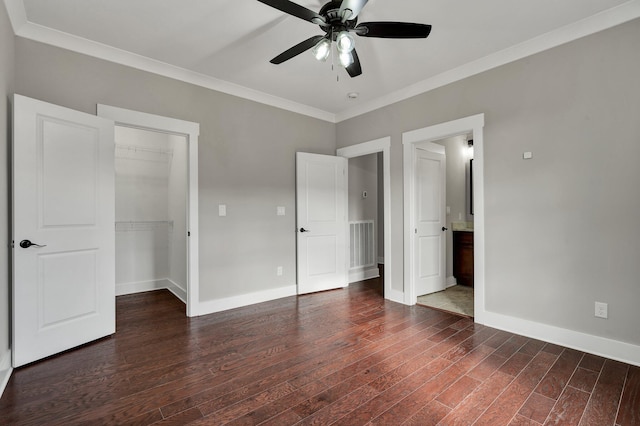 unfurnished bedroom featuring ceiling fan, a spacious closet, dark hardwood / wood-style floors, a closet, and ornamental molding