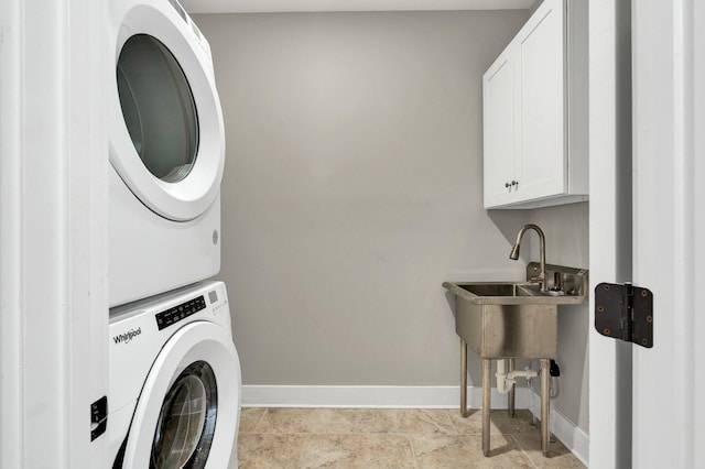 washroom featuring cabinets, stacked washer and dryer, and light tile patterned flooring