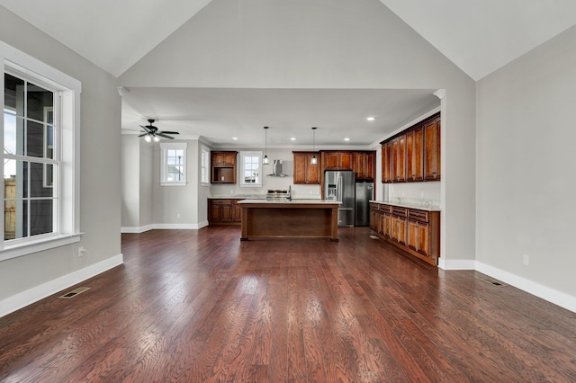 kitchen with a center island, wall chimney exhaust hood, hanging light fixtures, dark hardwood / wood-style floors, and stainless steel refrigerator with ice dispenser